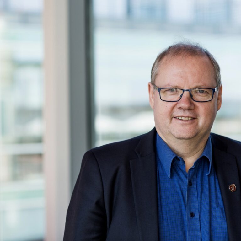 Jonny Gulbrandsen smilende med uklar bakgrunn. Portrett. Foto