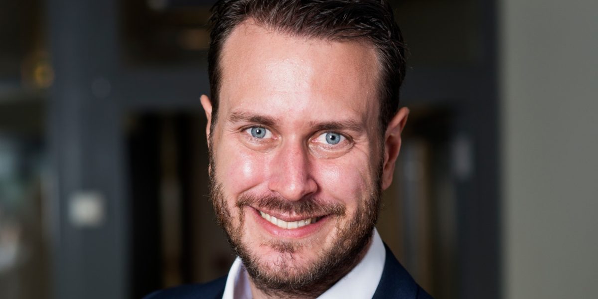 Helge Andre Njåstad smilende med uklar bakgrunn. Portrett. Foto