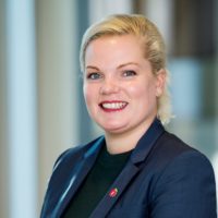 Silje Hjemdal smilende med uklar bakgrunn. Portrett. Foto