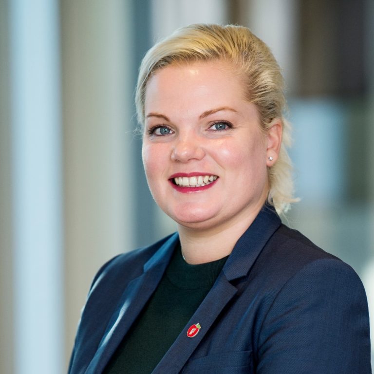 Silje Hjemdal smilende med uklar bakgrunn. Portrett. Foto