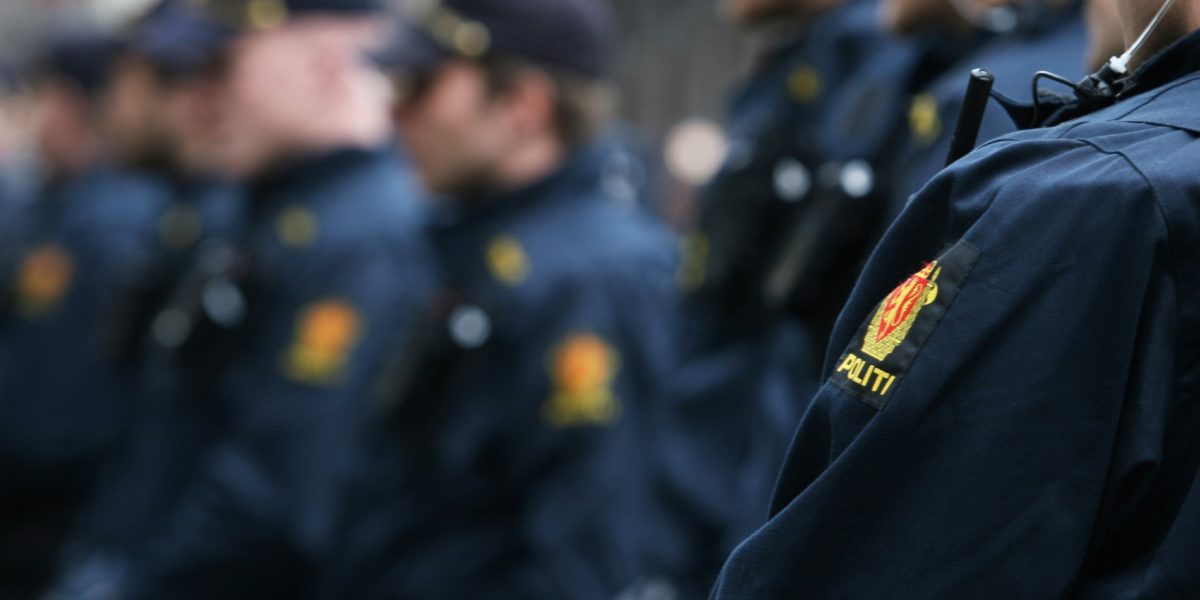 Uniformerte politifolk i rekke. Uklart bilde uten synlige ansikter. Foto