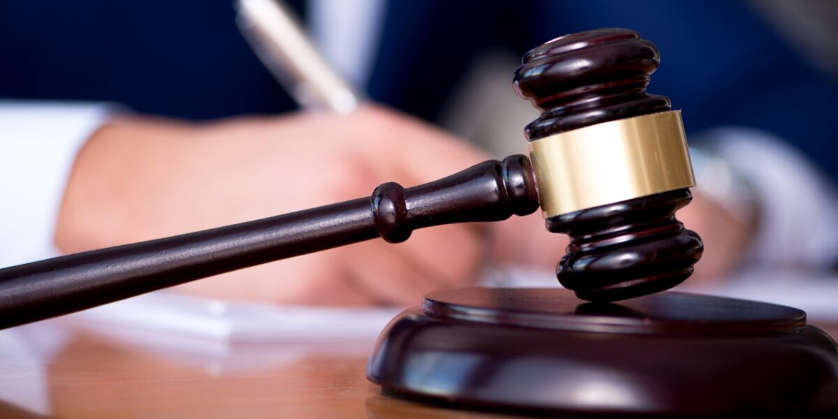 Dommerklubbe ligger foran en mann (uskarp) som skriver. Foto. Dommerklubbe ligger foran en mann (uskarp) som skriver. Foto.