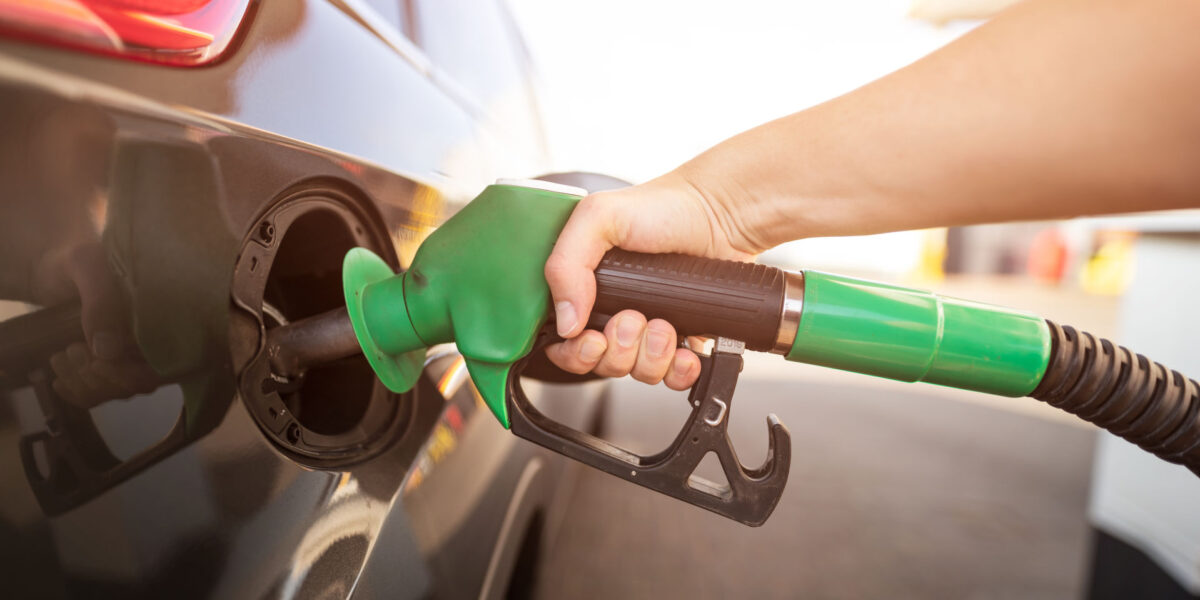 Person som fyller drivstoff på bil. Foto. Person som fyller drivstoff på bil. Foto.